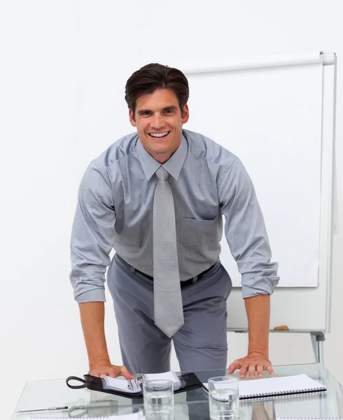 Веселый бизнесмен, опирающийся на конференц-стол — стоковое фото