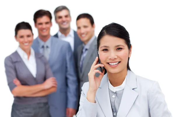 Asiatisk kvinna prata telefon framför hennes team — Stockfoto