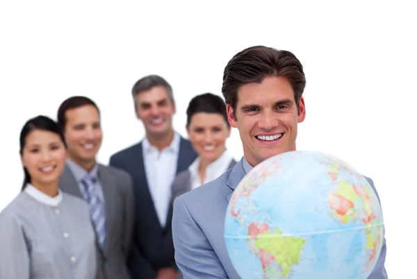 Selbstbewusster Geschäftsmann mit einer Weltkugel vor seinem Team — Stockfoto