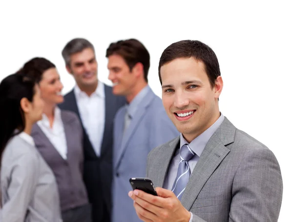 Confident businessman and his cellphone standing apart from his — Stock Photo, Image