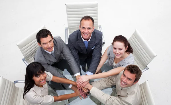 Sonriente equipo de negocios con las manos juntas —  Fotos de Stock