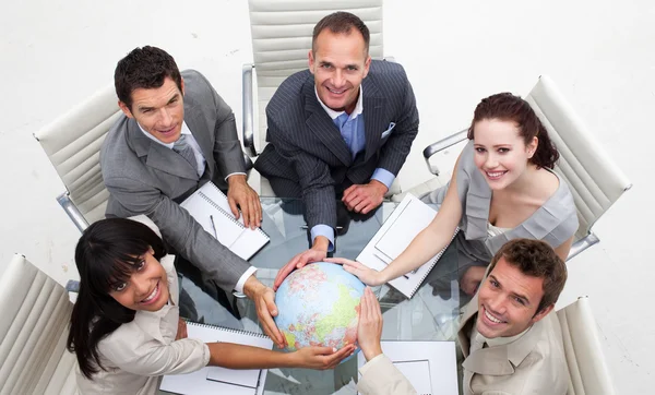 Alto ángulo de sonriente equipo de negocios sosteniendo el mundo — Foto de Stock