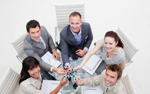 Alto ángulo de sonriente equipo de negocios sosteniendo moléculas —  Fotos de Stock