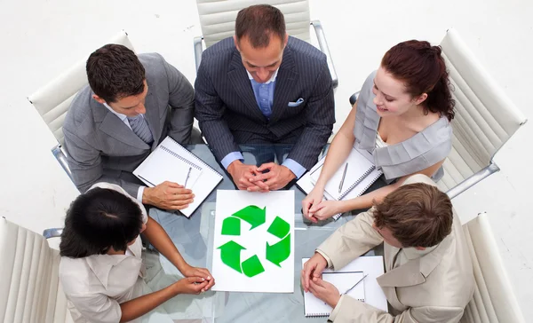 Alto ângulo da equipe de negócios olhando para um símbolo de reciclagem — Fotografia de Stock