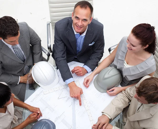 Arkitekt manager pekar på en plan i ett möte — Stockfoto
