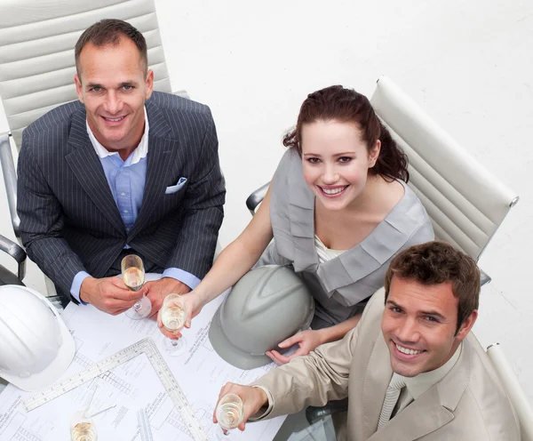 Arquitetos felizes bebendo champanhe no escritório — Fotografia de Stock