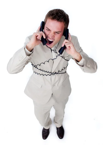 Empresário furioso emaranhado em fios de telefone — Fotografia de Stock