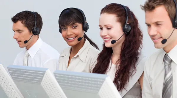 Etniska kvinna som arbetar med sitt team i ett callcenter — Stockfoto