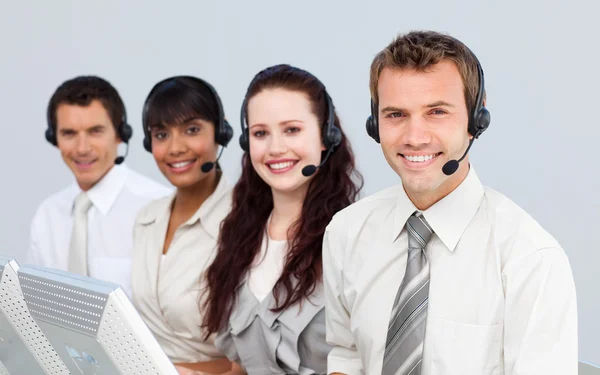 Sorrindo com um fone de ouvido em trabalhar em um call center — Fotografia de Stock