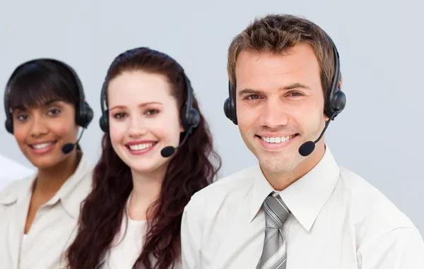 Jonge team met een headset over het werken in een callcenter — Stockfoto