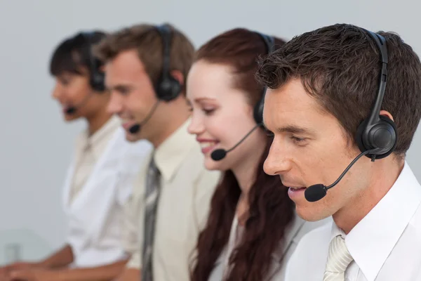 Aantrekkelijke man met een headset over het werken in een callcenter — Stockfoto