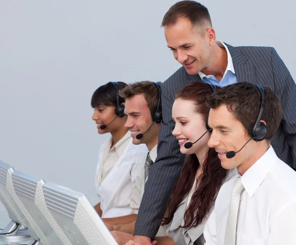 Gerente atraente verificando seu trabalho em equipe em um call center — Fotografia de Stock