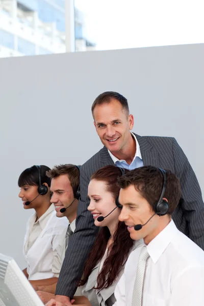 Gerente trabalhando com sua equipe em um call center — Fotografia de Stock