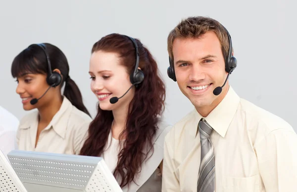 Smiling young businessman working in a call center — Stock Photo, Image