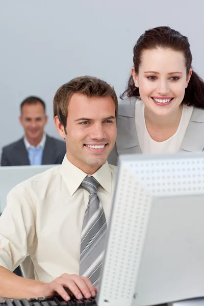 Partenaires commerciaux souriants travaillant ensemble sur un ordinateur — Photo