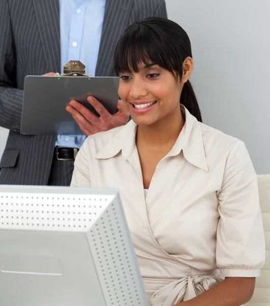 Bir bilgisayarda çalışan iş kadını gülümseyen — Stok fotoğraf