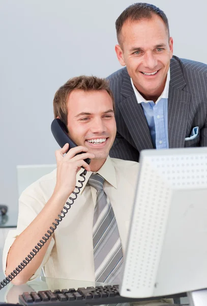 关于电话和与他的同事一起工作的商人 — 图库照片