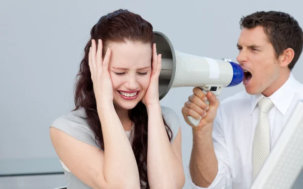 Businessman shouting through a megaphone at his colleague — Stock Photo, Image