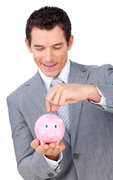 Leende affärsman spara pengar i en piggybank — Stockfoto