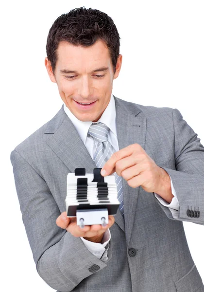 Attractive businessman consulting a business card holder — Stock Photo, Image