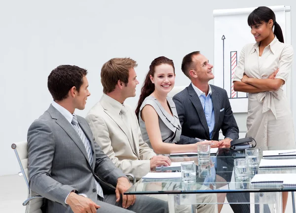 Lächelnde Geschäftsfrau hört seinem Kollegen beim Presen zu — Stockfoto