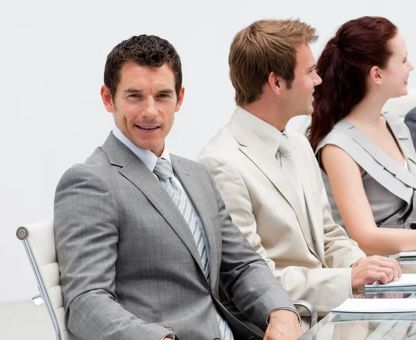 Привлекательный бизнесмен улыбается на встрече — стоковое фото