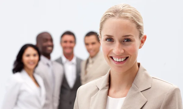 Portrait of smiling businesswoman in front of her team — Stock Photo, Image