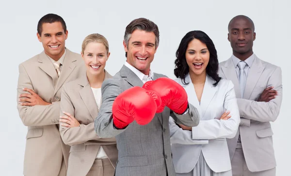 Улыбающийся бизнесмен в боксёрских перчатках возглавляет свою команду — стоковое фото