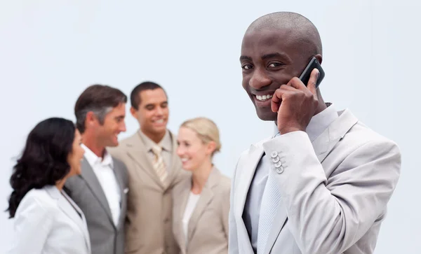 Афроамериканский бизнесмен по телефону на рабочем месте — стоковое фото