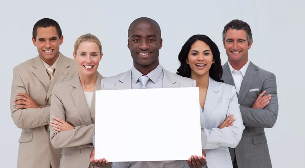 Empresário afro-americano segurando um cartão branco com sua equipe — Fotografia de Stock