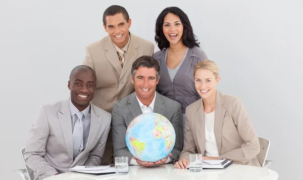 Business laget innehar en terrestrial globe — Stockfoto