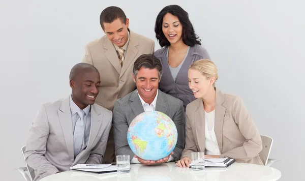 Equipe de negócios multi-étnica segurando um globo terrestre — Fotografia de Stock
