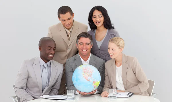 Business laget innehar en terrestrial globe — Stockfoto