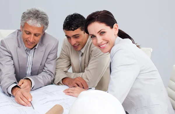 Portrait of a female engineer studying plans with her colleagues — Stock Photo, Image