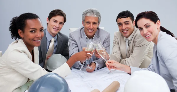 Uśmiechający się architectutal zespół świętować sukces z szampanem — Zdjęcie stockowe