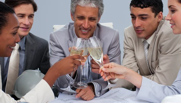 Крупный план счастливой команды архитекторов, пьющих шампанское — стоковое фото