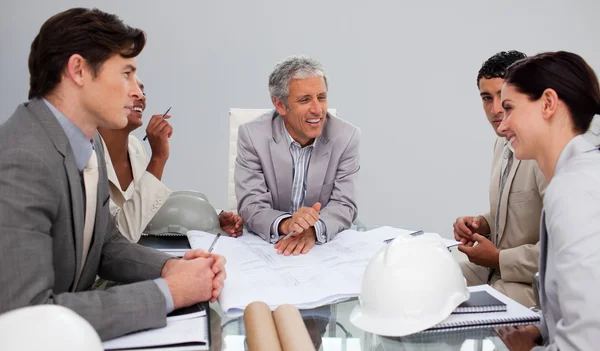 Architekten in einer Besprechung, die Pläne studiert — Stockfoto