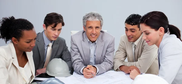 Architect manager in a meeting with his team studying plans — Stock Photo, Image