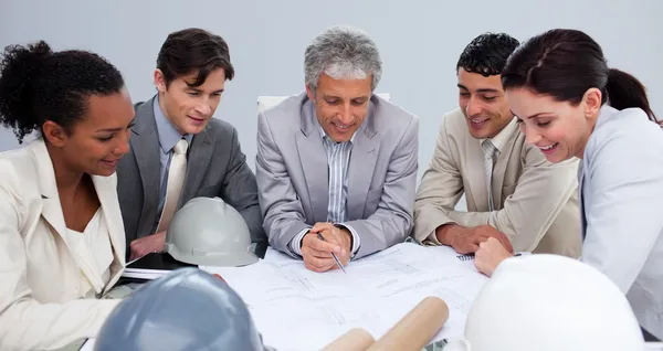 Ingenieros en una reunión estudiando planes — Foto de Stock