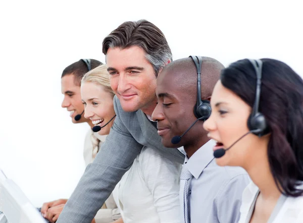 Handsome manager and his team working in a call center — Stock Photo, Image