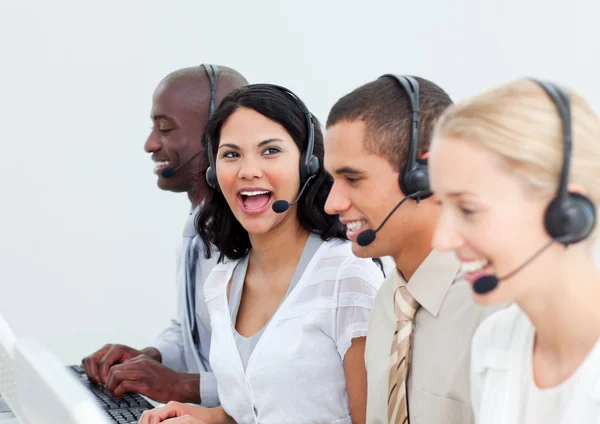 Skrattar affärskvinna och hennes team som arbetar i ett callcenter — Stock fotografie
