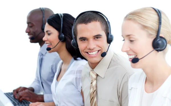 Sorrindo equipe de negócios falando sobre fone de ouvido — Fotografia de Stock