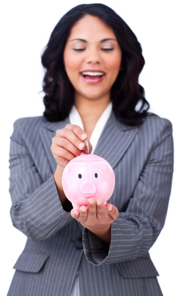 Positive businesswoman saving money in a piggybank — Stock Photo, Image