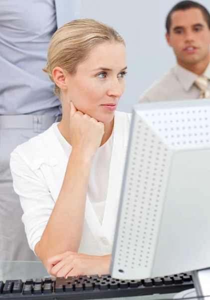 Mujer rubia pensativa trabajando en una computadora — Foto de Stock