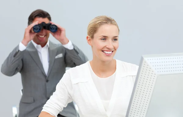 Ambitious manager holding binoculars looking at his colleague's — Stock Photo, Image