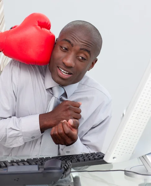 Ethnic businessman hit by a boxing glove — Stock Photo, Image