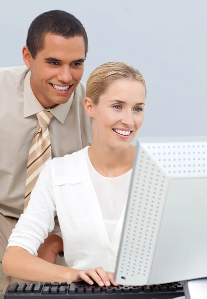 Gerente alegre ajudando uma mulher de negócios com seu computador — Fotografia de Stock