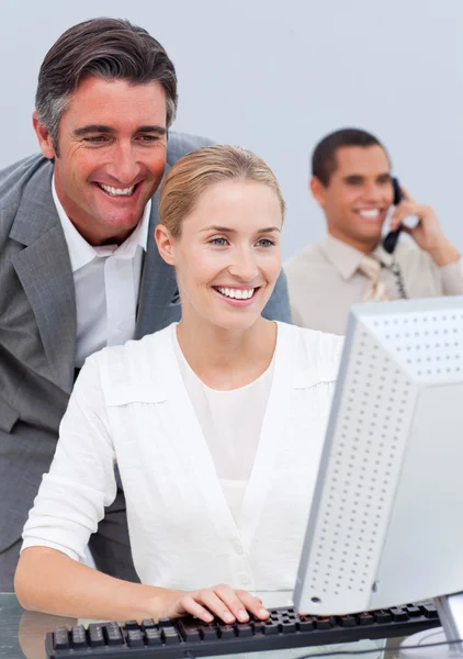 Smiling business team working at a computer — Stock Photo, Image