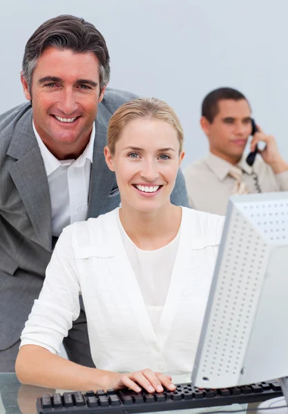 Confident business team working at a computer — Stock Photo, Image