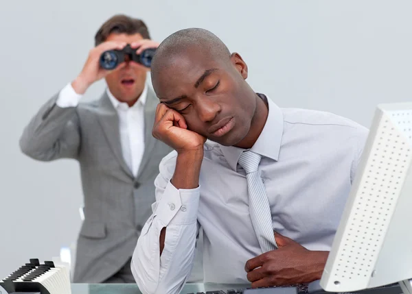 Ethnic businessman annoyed by a man looking through binoculars — Stock Photo, Image